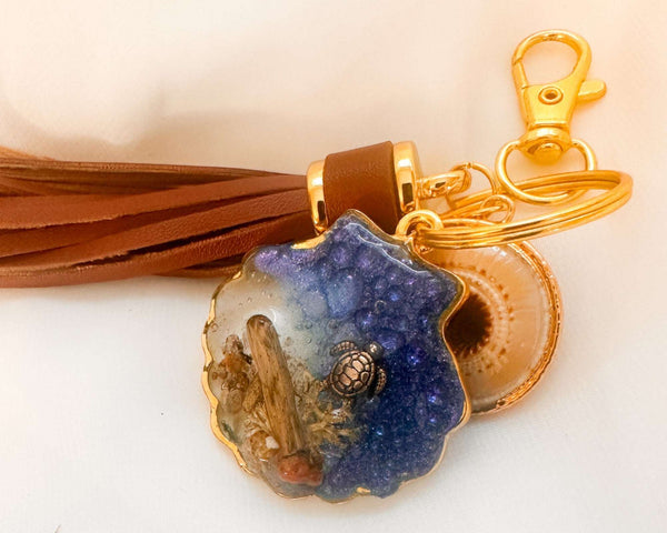 Handmade "Coastal Embrace" Keychain ($42): Real sand, seashells, & a silver turtle in glittering blue resin. Unique, luxury leather tassel & gold charm.