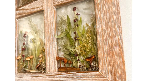 Wooden frame with glass panels displaying nature-themed decorations
