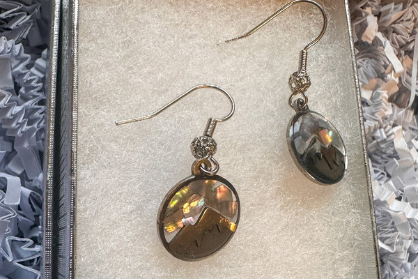 Pair of earrings in a decorative box with crinkled paper background