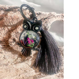 Close-up of handmade owl bag charm showing Northern Lights resin cabochon with pressed ferns