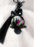 Close-up of handmade owl bag charm showing Northern Lights resin cabochon with pressed ferns