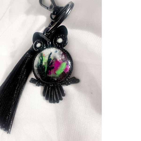 Close-up of handmade owl bag charm showing Northern Lights resin cabochon with pressed ferns