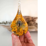 Holding a handmade resin ring holder with real black-eyed susan and sunflower with gold leaf accents