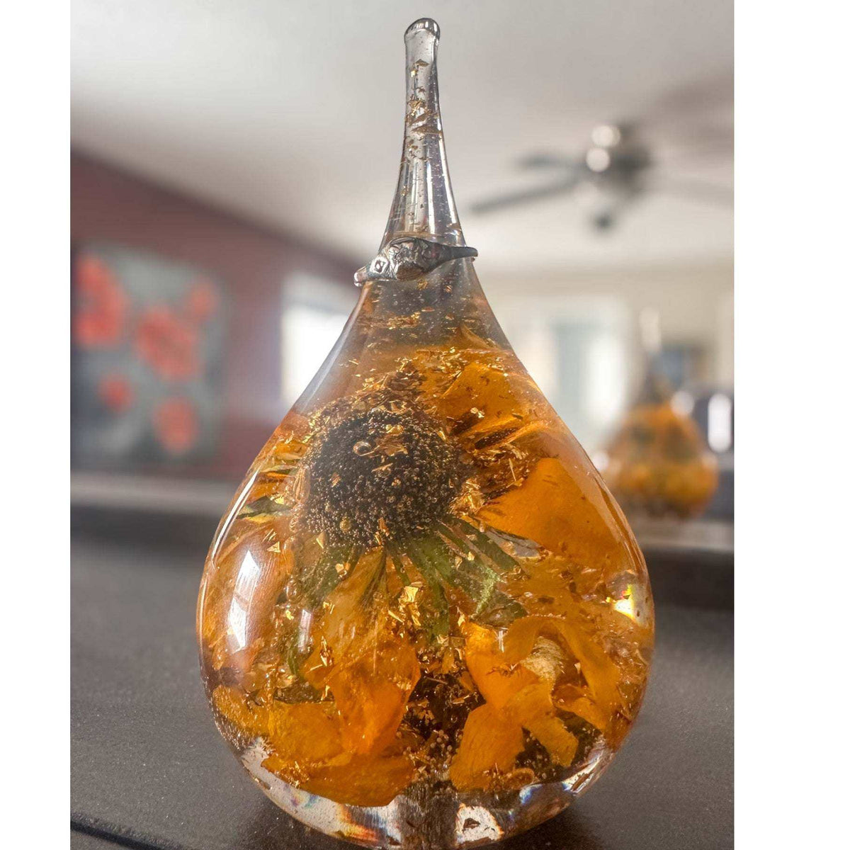 A lifestyle shot of the resin ring holder with a delicate gold ring resting on the tapered top spike.