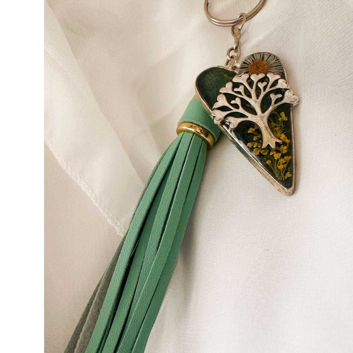 Secret Garden Bag Charm & Silver Tree of Life heart charm with a moss green resin background, real yellow flowers, and a tiny daisy, featuring a green leather tassel.