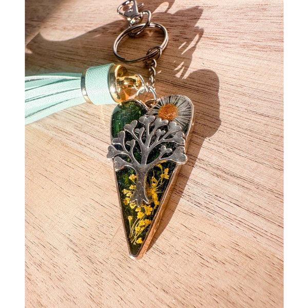 Secret Garden Bag Charm & Silver Tree of Life heart charm with a moss green resin background, real yellow flowers, and a tiny daisy, featuring a green leather tassel.
