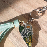 Secret Garden Bag Charm & Silver Tree of Life heart charm with a moss green resin background, real yellow flowers, and a tiny daisy, featuring a green leather tassel.