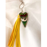 Close up of the silver sloth heart bag charm and real preserved greenery encased in shimmering green resin.