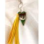Close up of the silver sloth heart bag charm and real preserved greenery encased in shimmering green resin.