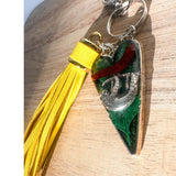 Close up of the silver sloth heart bag charm and real preserved greenery encased in shimmering green resin.