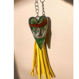 Close up of the silver sloth heart bag charm and real preserved greenery encased in shimmering green resin.