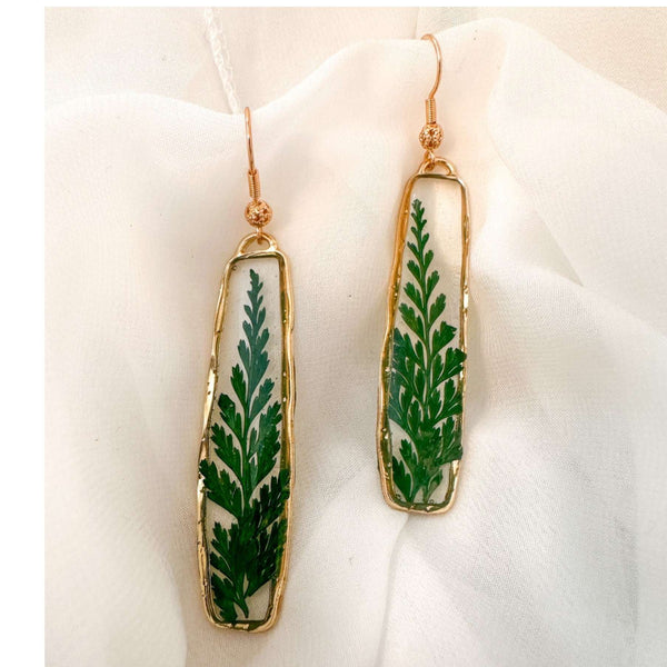 Handcrafted Fern's Embrace drop earrings featuring real green fern fronds in a clear resin setting.