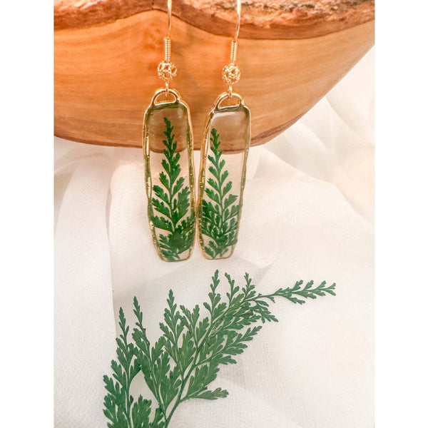 Handcrafted Fern's Embrace drop earrings featuring real green fern fronds in a clear resin setting.