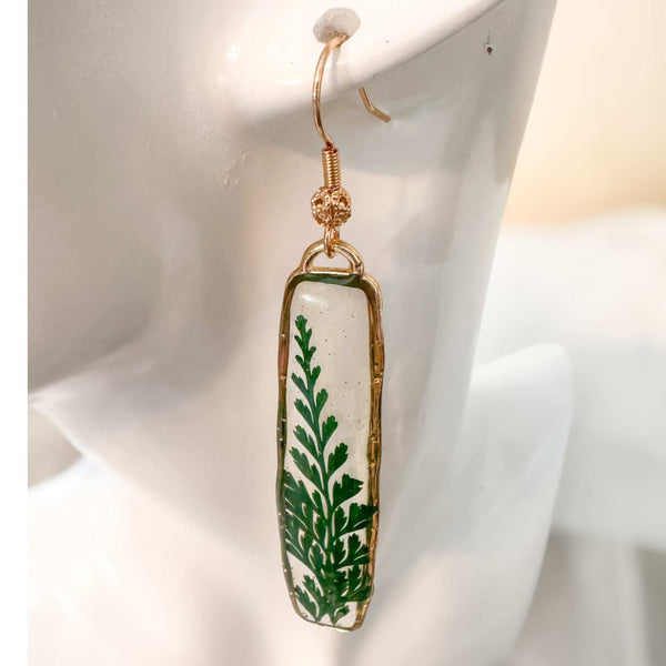 Handcrafted Fern's Embrace drop earrings featuring real green fern fronds in a clear resin setting.