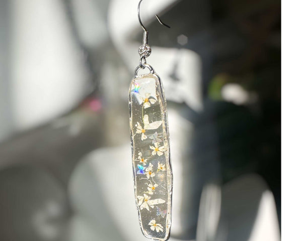 Long organic-edged Floral Butterfly drop earrings featuring tiny white spring flowers and miniature butterflies floating in clear resin.