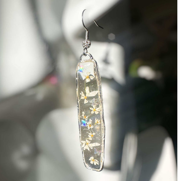 Long organic-edged Floral Butterfly drop earrings featuring tiny white spring flowers and miniature butterflies floating in clear resin.