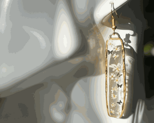 Long organic-edged Floral Butterfly drop earrings featuring tiny white spring flowers and miniature butterflies floating in clear resin.