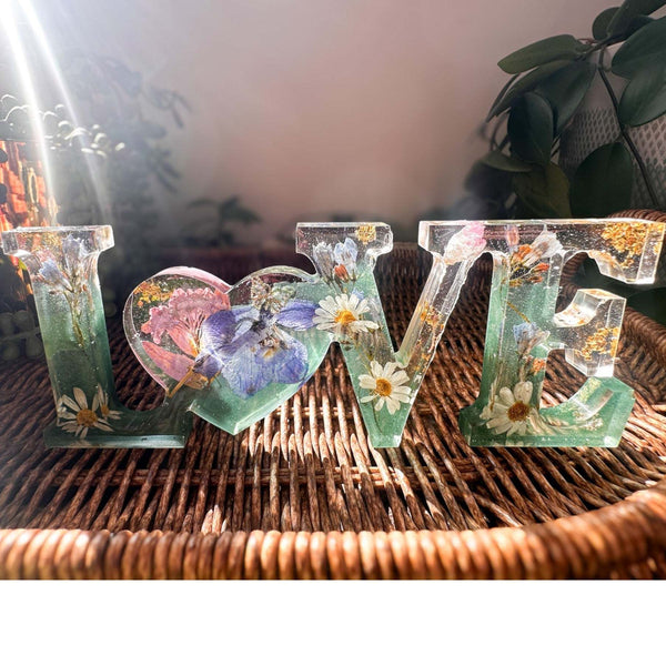 Handcrafted "LOVE" floral resin sign with deep green and clear layers.