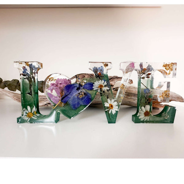 Handcrafted "LOVE" floral resin sign with deep green and clear layers.