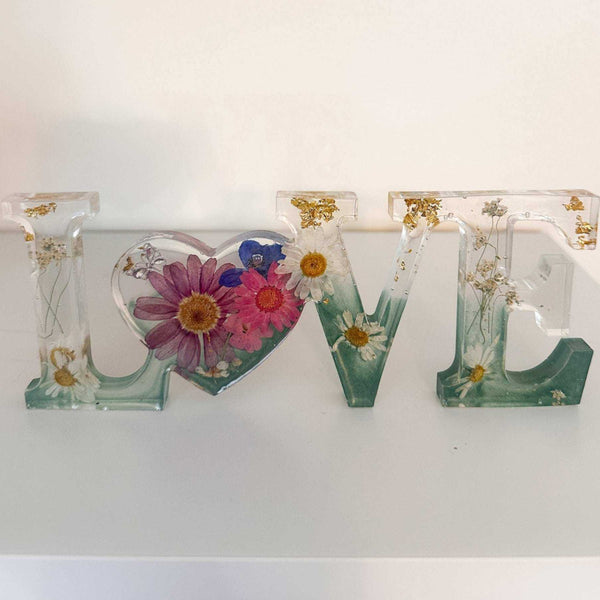 Handcrafted floral resin LOVE sign with a large pink cosmo and forest green base.