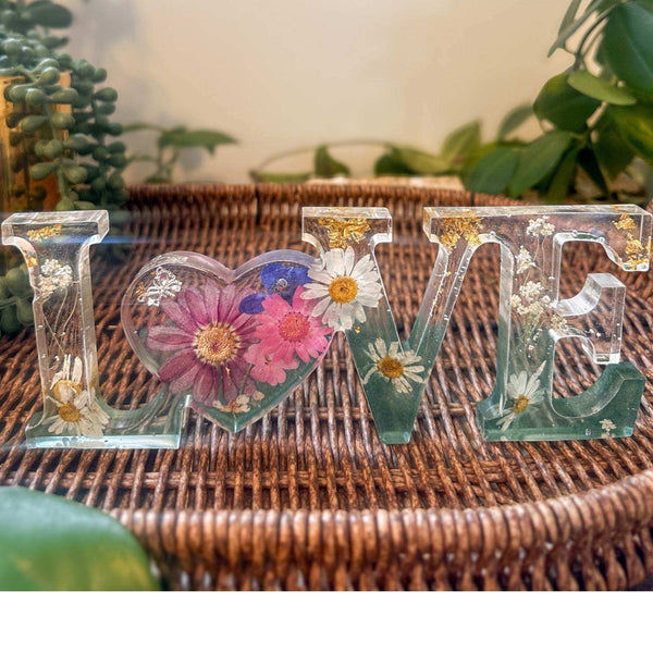 Handcrafted floral resin LOVE sign with a large pink cosmo and forest green base.
