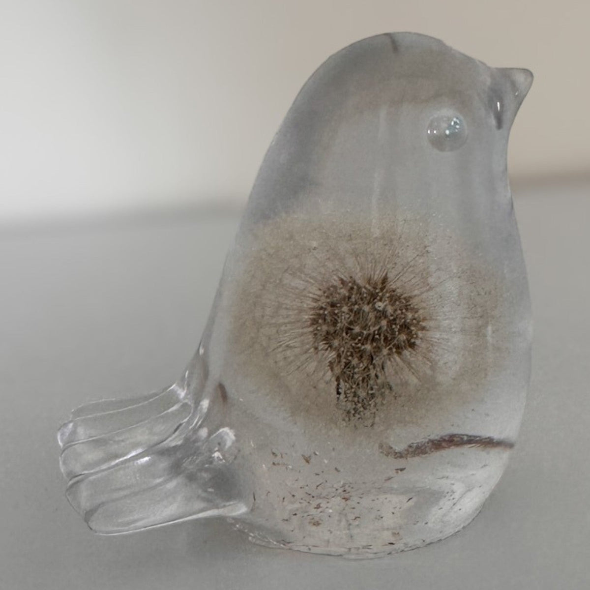 Wish Keeper Songbird dandelion resin bird on a sunny surface catching natural light