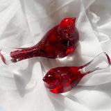 Close-up of glossy red berries suspended in clear hand-poured resin bird with red glitter shimmer