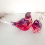 Close-up of real dried fuchsia flowers suspended in deep pink and purple hand-poured resin bird