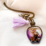 Close-up of real dried forest mushrooms and ferns inside purple shimmer clear resin bottle bookmark charm
