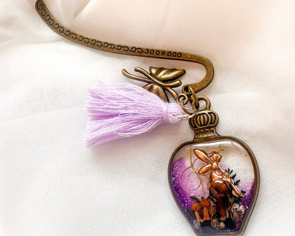 Close-up of real dried forest mushrooms and ferns inside purple shimmer clear resin bottle bookmark charm