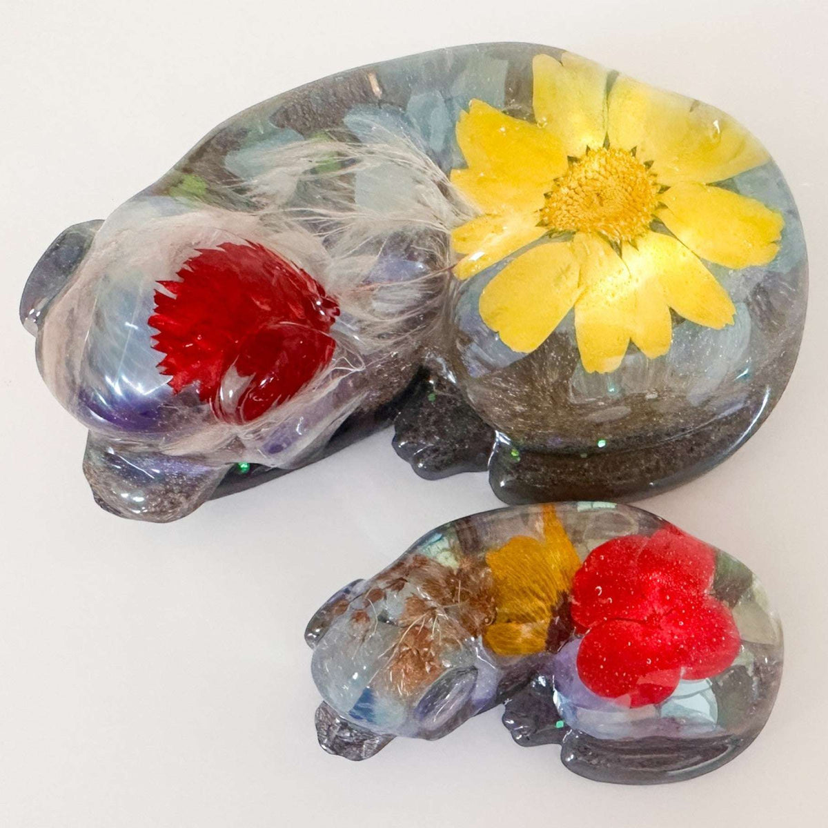 Handmade custom resin memorial pet figurine of resting dog with floral inclusions and personalized ashes and fur keepsake
