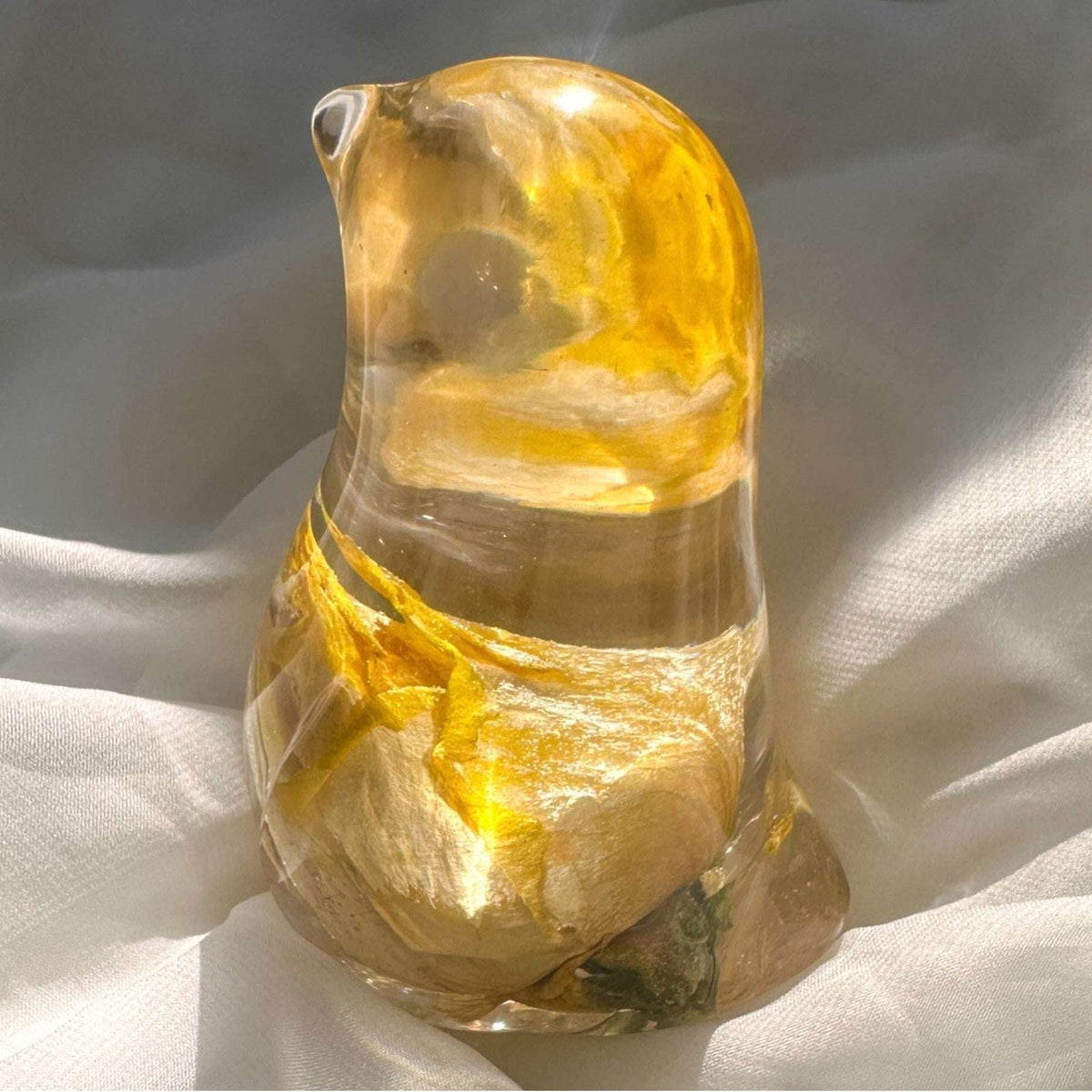 Close-up of real yellow rose bud with golden outer petals and cream inner petals preserved in clear hand-poured resin bird