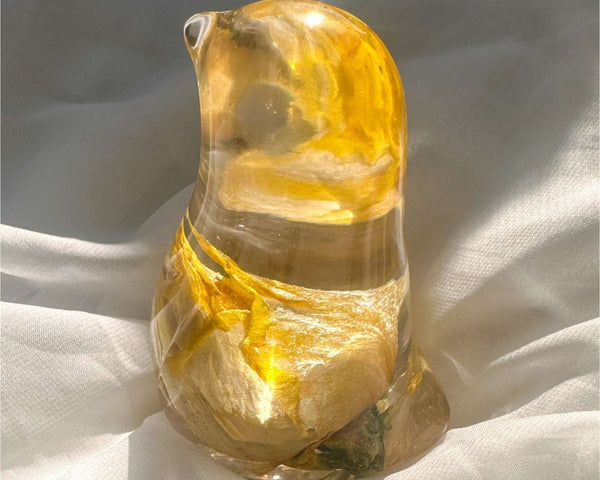 Close-up of real yellow rose bud with golden outer petals and cream inner petals preserved in clear hand-poured resin bird