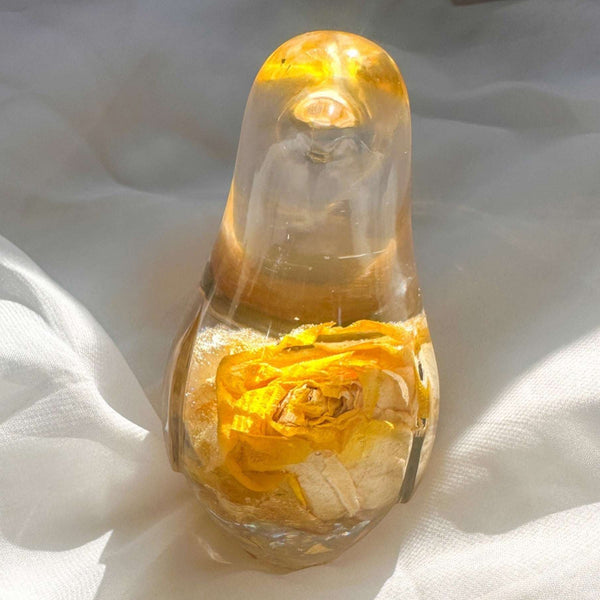 Close-up of real yellow rose bud with golden outer petals and cream inner petals preserved in clear hand-poured resin bird