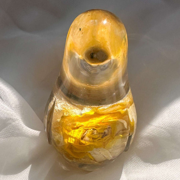 Close-up of real yellow rose bud with golden outer petals and cream inner petals preserved in clear hand-poured resin bird