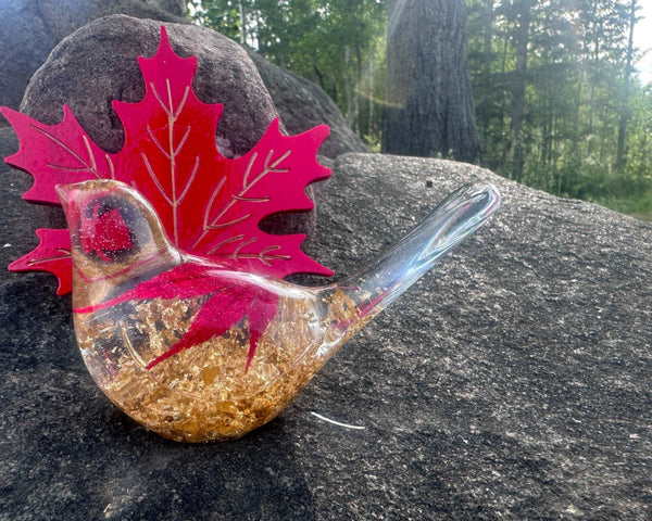 Maple Leaf Songbird, clear resin bird with gold flecks and a vivid red maple leaf detail inside.