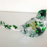 Clear resin bird figurine filled with real green four leaf clovers, vibrant green botanicals, and gold flakes,