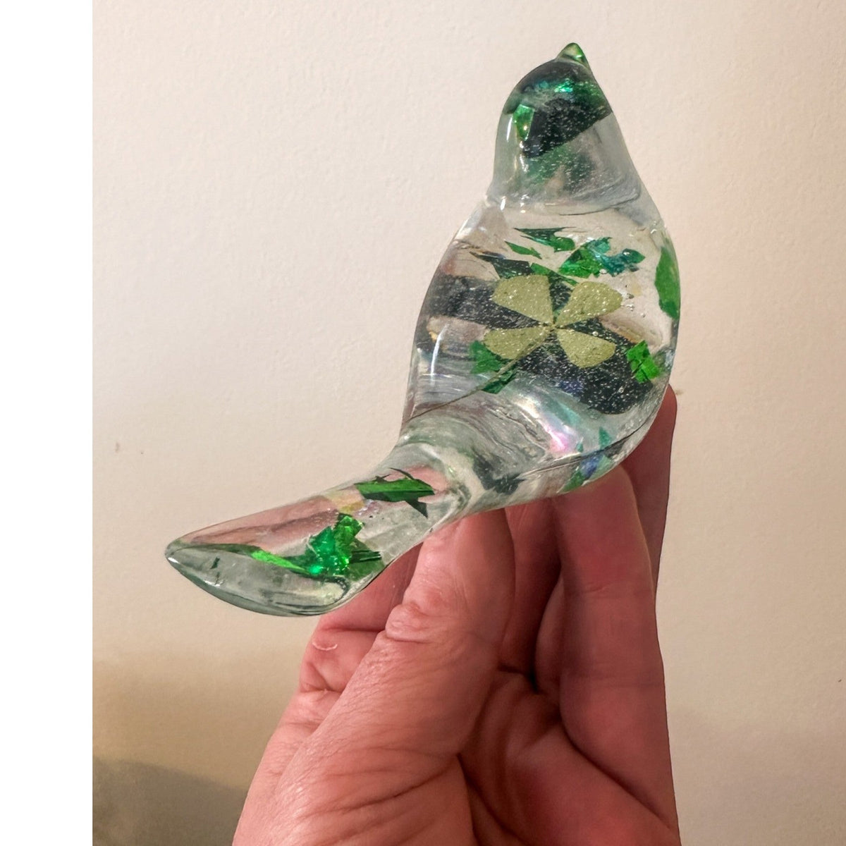 Clear resin bird figurine filled with real green four leaf clovers, vibrant green botanicals, and gold flakes,