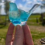 Aurora Wish Songbird teal glow resin bird decor glowing softly in a dark room held in hand