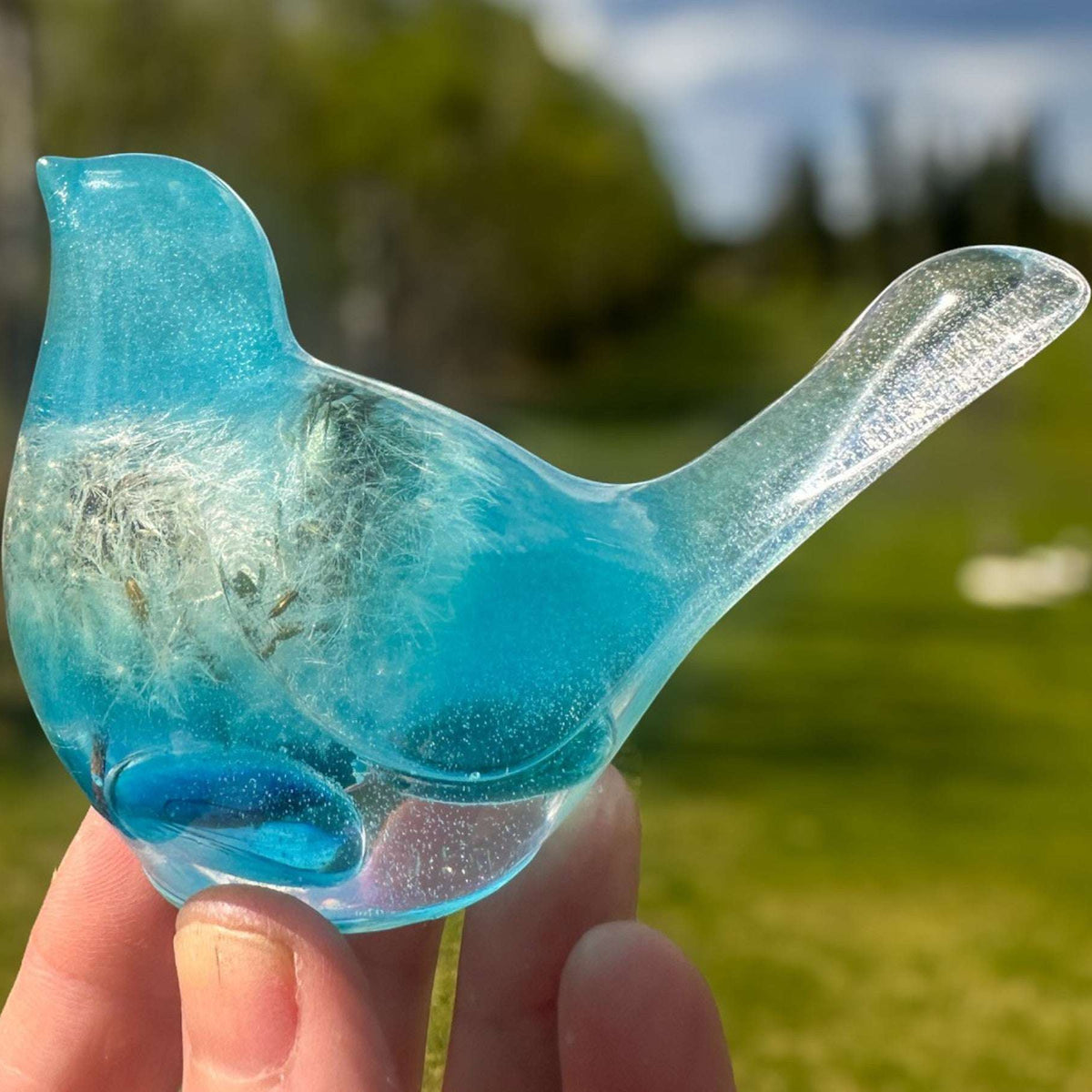 Aurora Wish Songbird teal glow resin bird decor glowing softly in a dark room held in hand