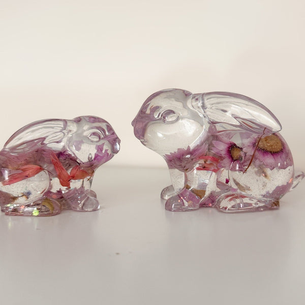 Small and large Blossom and Burrow pink floral resin bunny decor set displayed together on a shelf