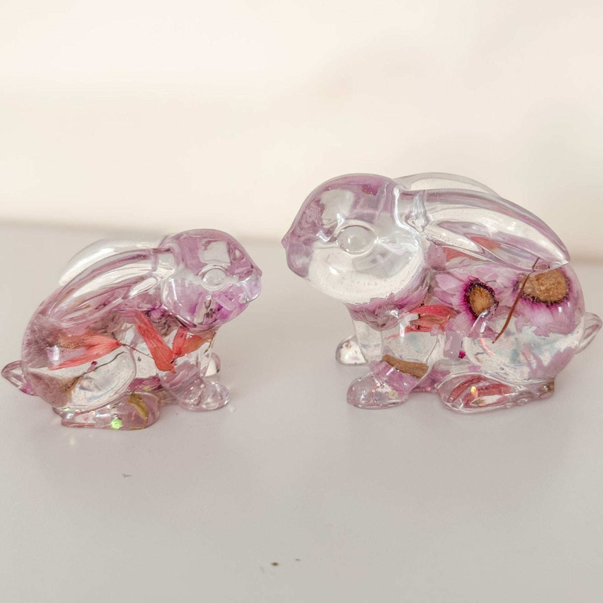 Small and large Blossom and Burrow pink floral resin bunny decor set displayed together on a shelf