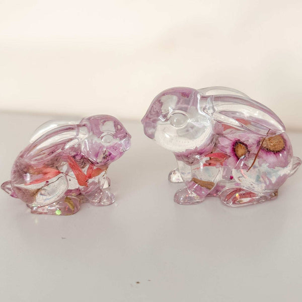 Small and large Blossom and Burrow pink floral resin bunny decor set displayed together on a shelf