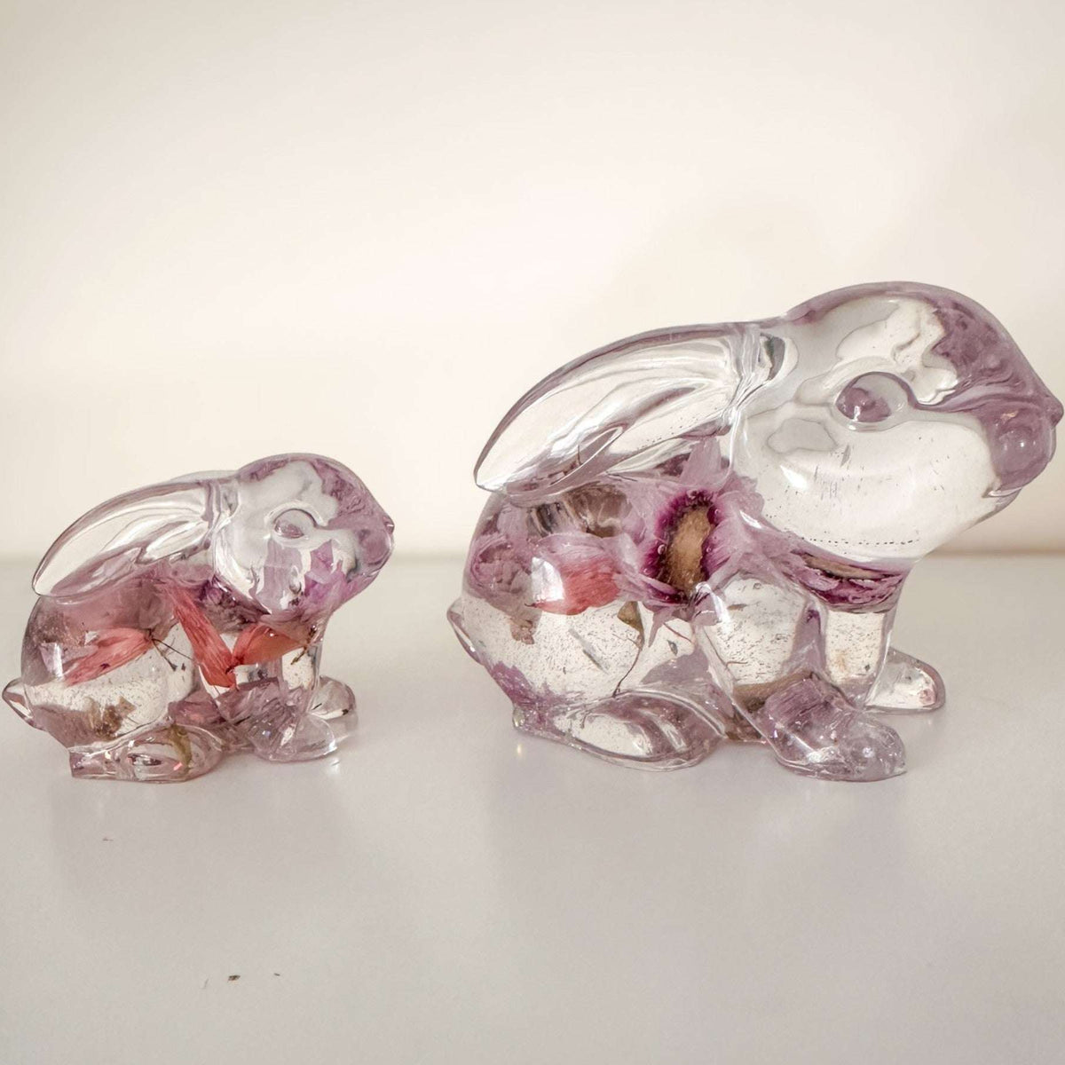 Small and large Blossom and Burrow pink floral resin bunny decor set displayed together on a shelf