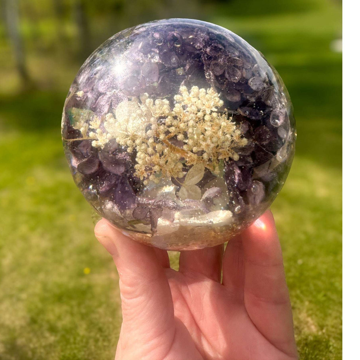 Purple lilac resin sphere with real lilac blooms and LED light base glowing softly