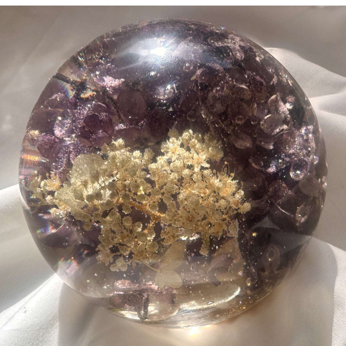 Purple lilac resin sphere with real lilac and hydrangea blooms glowing on LED light base