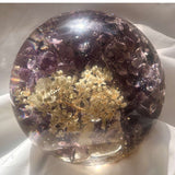 Purple lilac resin sphere with real lilac and hydrangea blooms glowing on LED light base