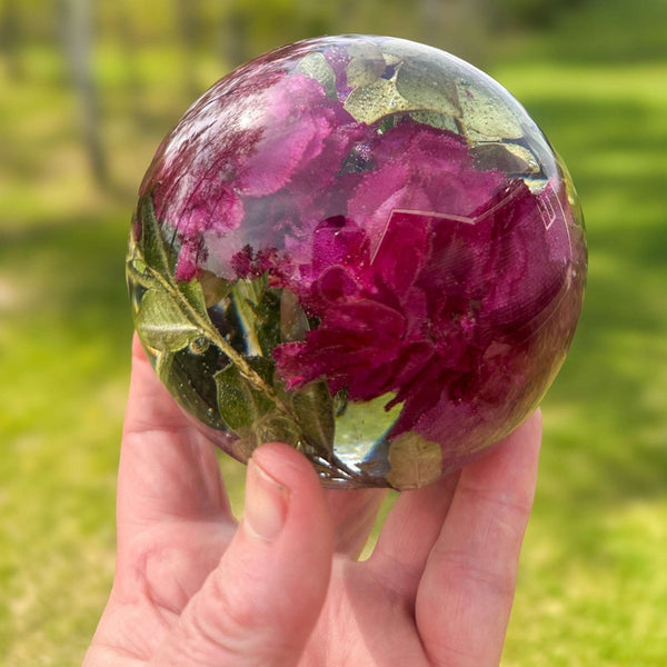 Handcrafted floral resin sphere with real dark pink and purple carnations and LED glowing base