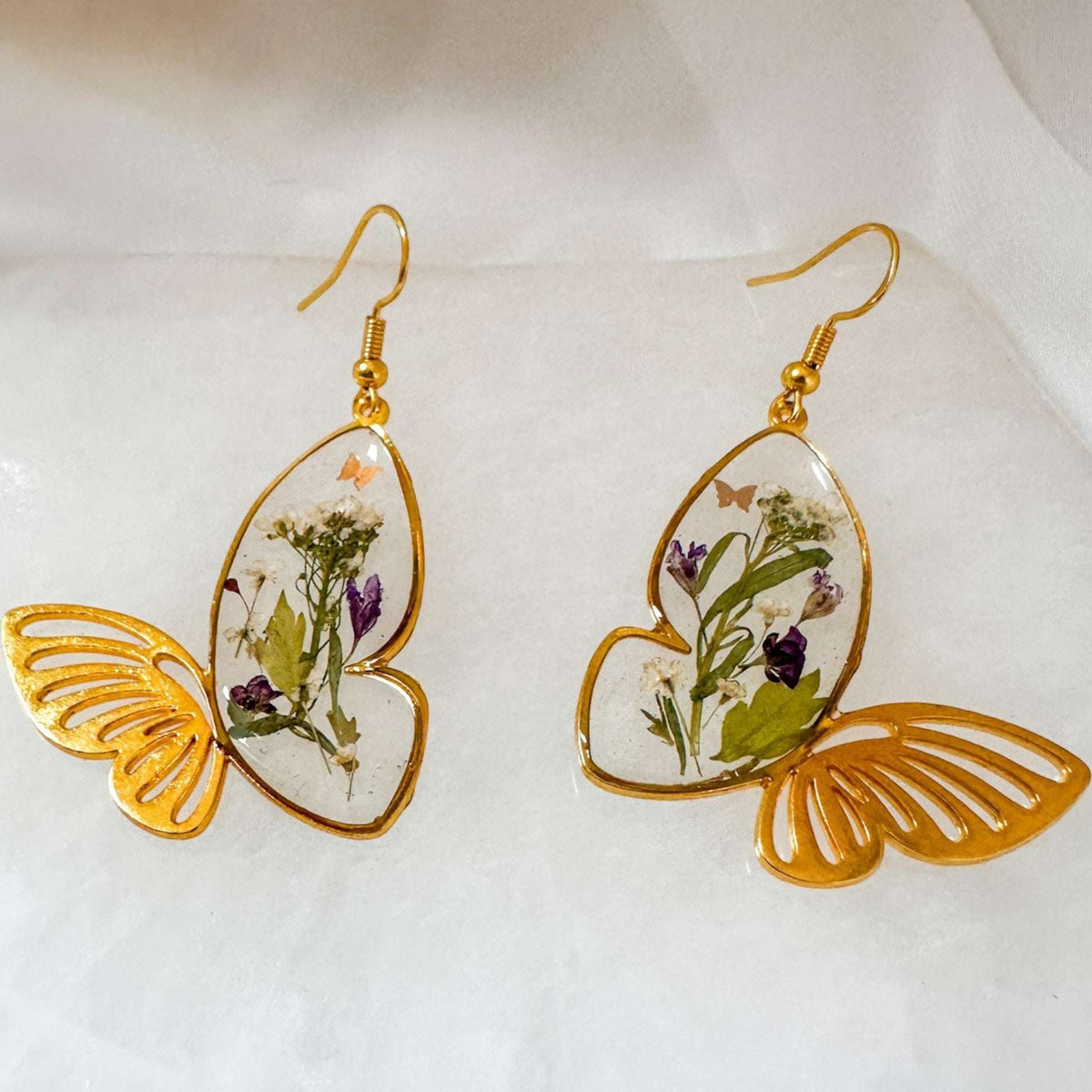 Handmade Fluttering Blossom earrings with real pressed flowers in resin butterfly wings and delicate butterfly accents