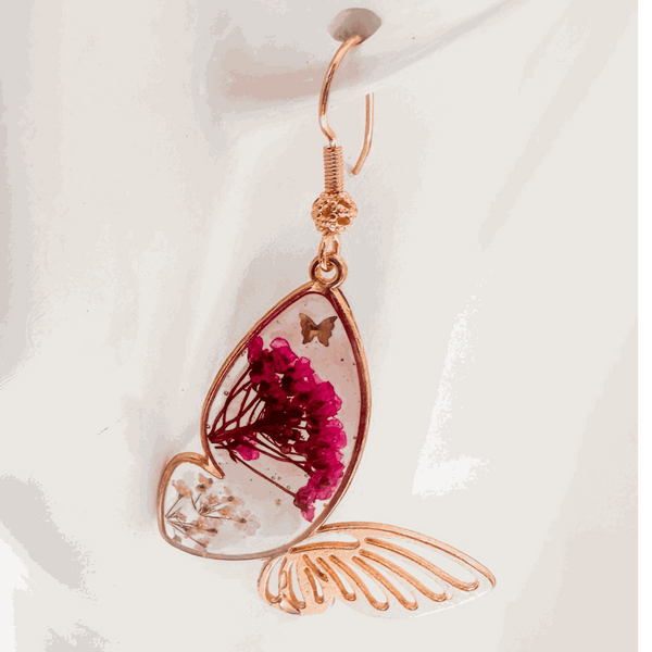 Rose gold Garden Wing Earrings with pressed deep pink and white flowers in resin butterfly wings and gold butterfly accent